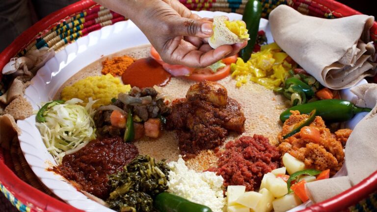 Addis ababa Ethiopia food tour-mahberawi- enjera bread topped with pea,grind meat,chicken stew with eggs,vegitables eating with hand